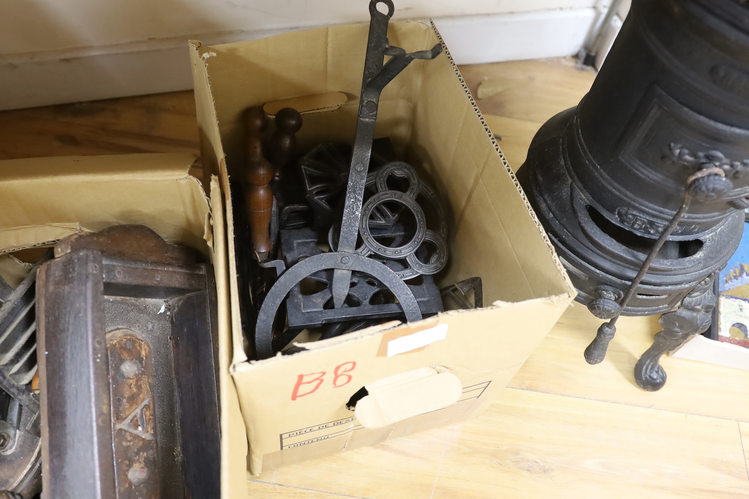 A collection of vintage domestic iron implements, including a cylindrical iron stove